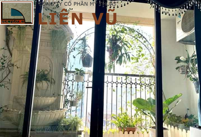 Tiểu cảnh vườn ban công với chậu hoa treo và đài nước