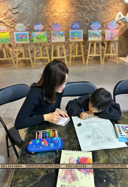 họa sĩ Nguyễn Vũ Quỳnh Trang đang hướng dẫn các bé vẽ