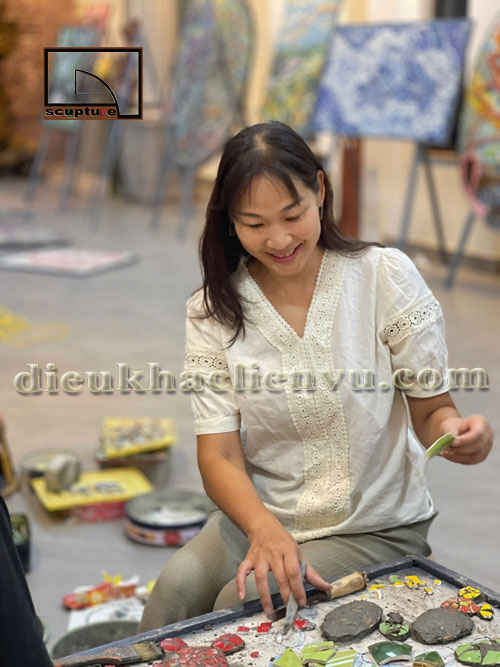 họa sĩ Quỳnh Liên đang thực hiện bức tranh từ chất thải rắn