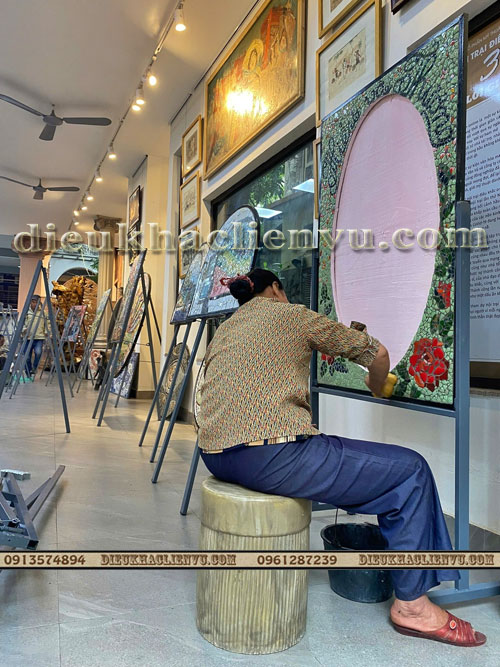 nghệ sĩ đang thực hiện bức tranh từ chất thải rắn