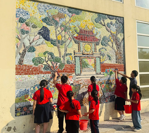 Các em học sinh trường tiểu học Liên Mạc đang chỉnh trang lại bức tranh Văn Miếu