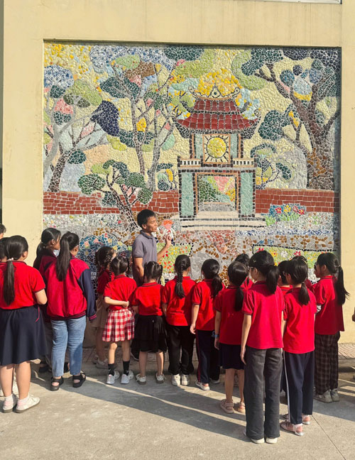 Thầy trò trường tiểu học Liên Mạc đang ngắm nhìn bức tranh Văn Miếu - Bức tranh được làm từ chất thải rắn